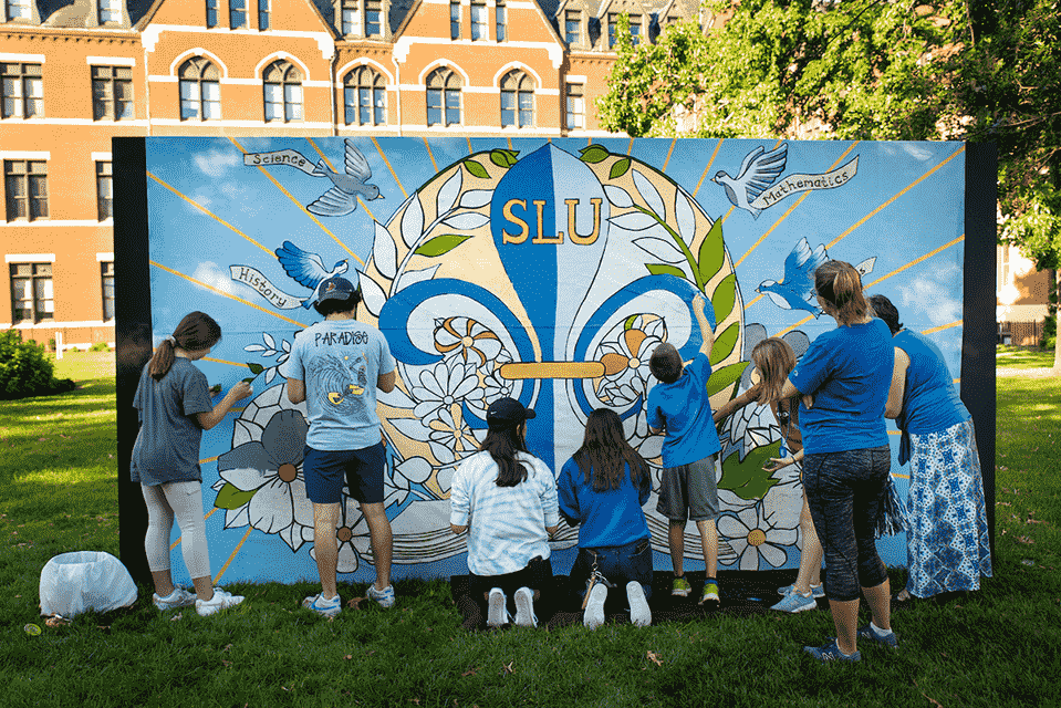 Homecoming mural A group of eight students paint a mural together.
