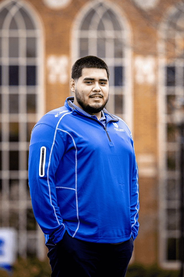 Gael Cosgaya outside of Business School Gael Cosgaya poses for a photo outside of a brick building on campus.