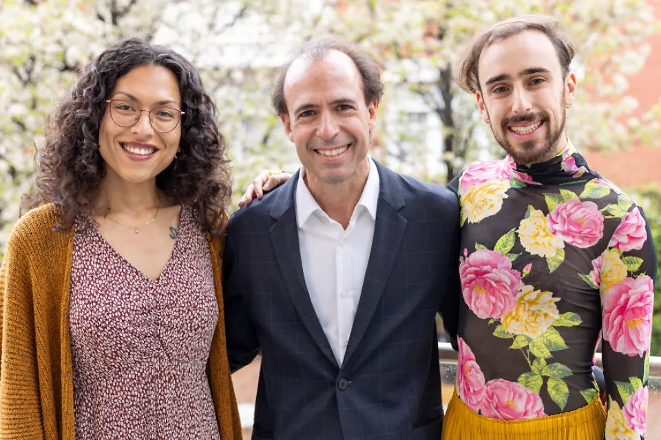 The members of SLU-Madrid counseling team pose for a group photo in front of blossoming trees.