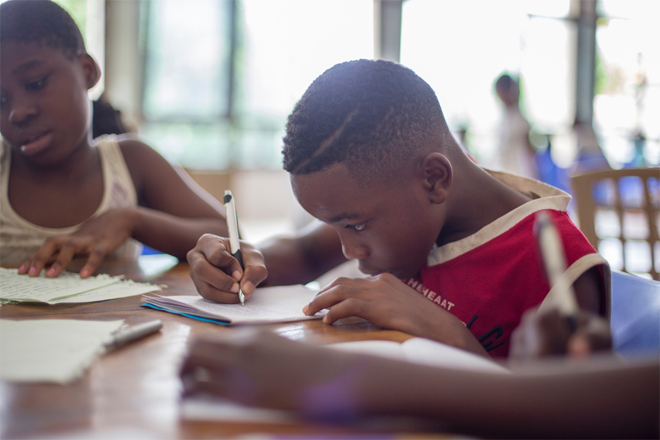 young-boy-doing-homework Picture of a young boy during class doing homework