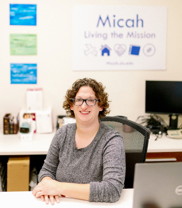 Emily Komos Emily Komos sits at a desk