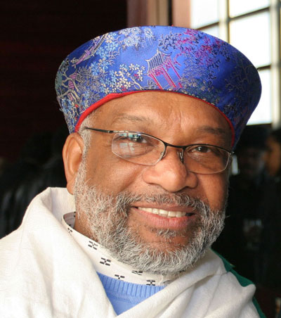 Chester Higgins Photographer Chester Higgins dons a white shawl and a low-profile hat with sapphire-blue silk in a pagoda motif